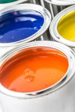 Full of multicolored paint cans on white table Stock Photos