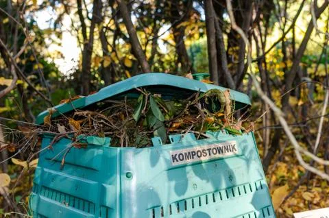 Full Outside plastic  compost container with leaves and branches. Text on pol 库存照片