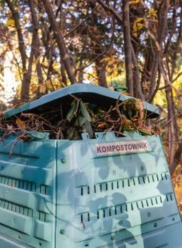 Full Outside plastic  compost container with leaves and branches. Text on pol Stock Photos