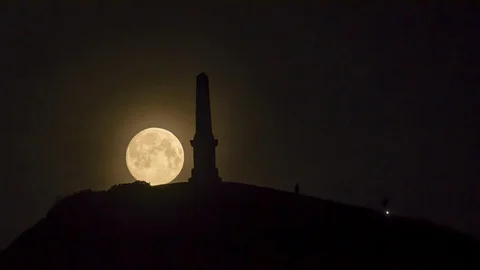 The full pink super moon sets behind Kildoon monument, South Ayrshire, Scotland. Stock Footage 128354177