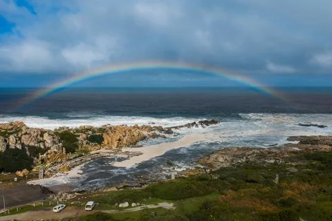 Full rainbow over Atlantic surf at Cape Peninsula, Cape Town coast Fotos Stock
