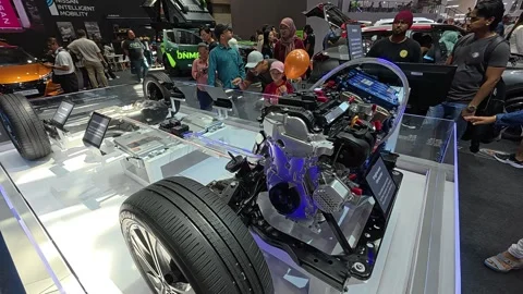 A full-scale hybrid engine model, integrated into a car chassis, is showcased Stock Footage 311555143