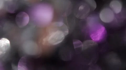 Full-screen bokeh of sparkling white and purple sparkles on a black screen. Stockbeeldmateriaal 318068614