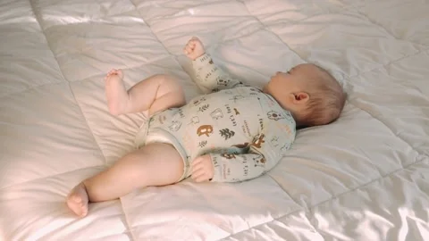 Full  shot of beautiful two-month-old newborn baby child  lying down on back Stock Footage 165846610