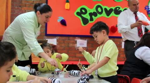 FULL SHOT. Children doing school activities, mistress help them. Stock-Footage 48435457