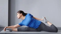 Flexible Asian woman practicing yoga on floor · Free Stock Photo