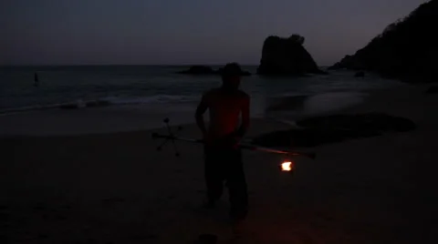 FULL SHOT. Man doing fire juggling in the beach in front to the sea at night. Stock Footage 49757113