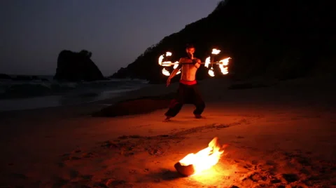 FULL SHOT. Man doing fire juggling in the beach in front to the sea at night. Stock Footage 49757207