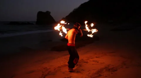 FULL SHOT. Man doing fire juggling in the beach in front to the sea at night. Stock Footage 49757304