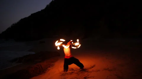 FULL SHOT. Man doing fire juggling in the beach in front to the sea at night. Stock Footage 49757491
