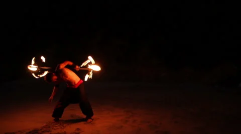 FULL SHOT. Man doing fire juggling in the beach in front to the sea at night. Stock Footage 49757585