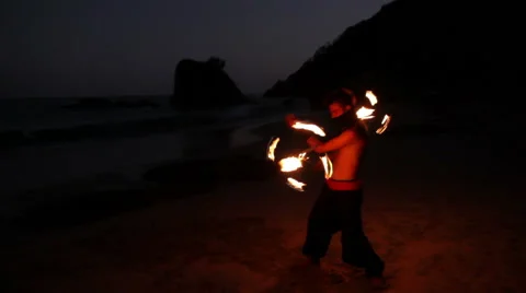 FULL SHOT. Man doing fire juggling in the beach in front to the sea at night. Stock Footage 49757732