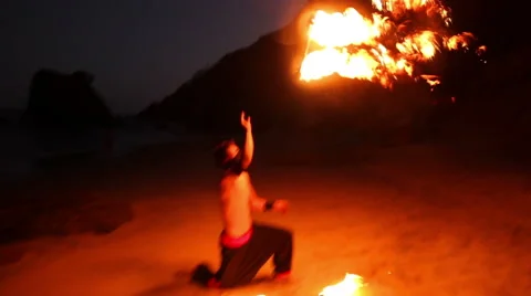 FULL SHOT. Man doing fire juggling in the beach in front to the sea at night. Stock Footage 49757881