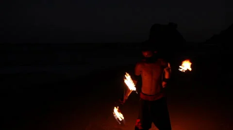 FULL SHOT. Man doing fire juggling in the beach in front to the sea at night. Stock Footage 49758746