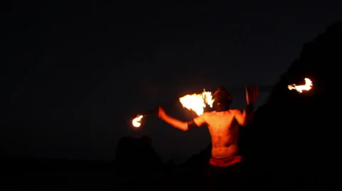 FULL SHOT. Man doing fire juggling in the beach in front to the sea at night. Stock Footage 49758854