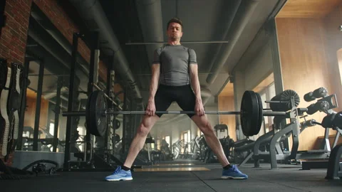 Full shot of young athletic man performing deadlift with barbell in gym Stock Footage 241589996