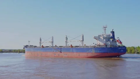 Full side view of a large blue cargo vessel with multiple deck cranes saili.. Stock Footage 345939424