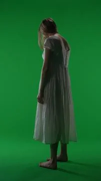 Full-size half turn vertical green screen, chroma key shot of a posessed female Foto stock