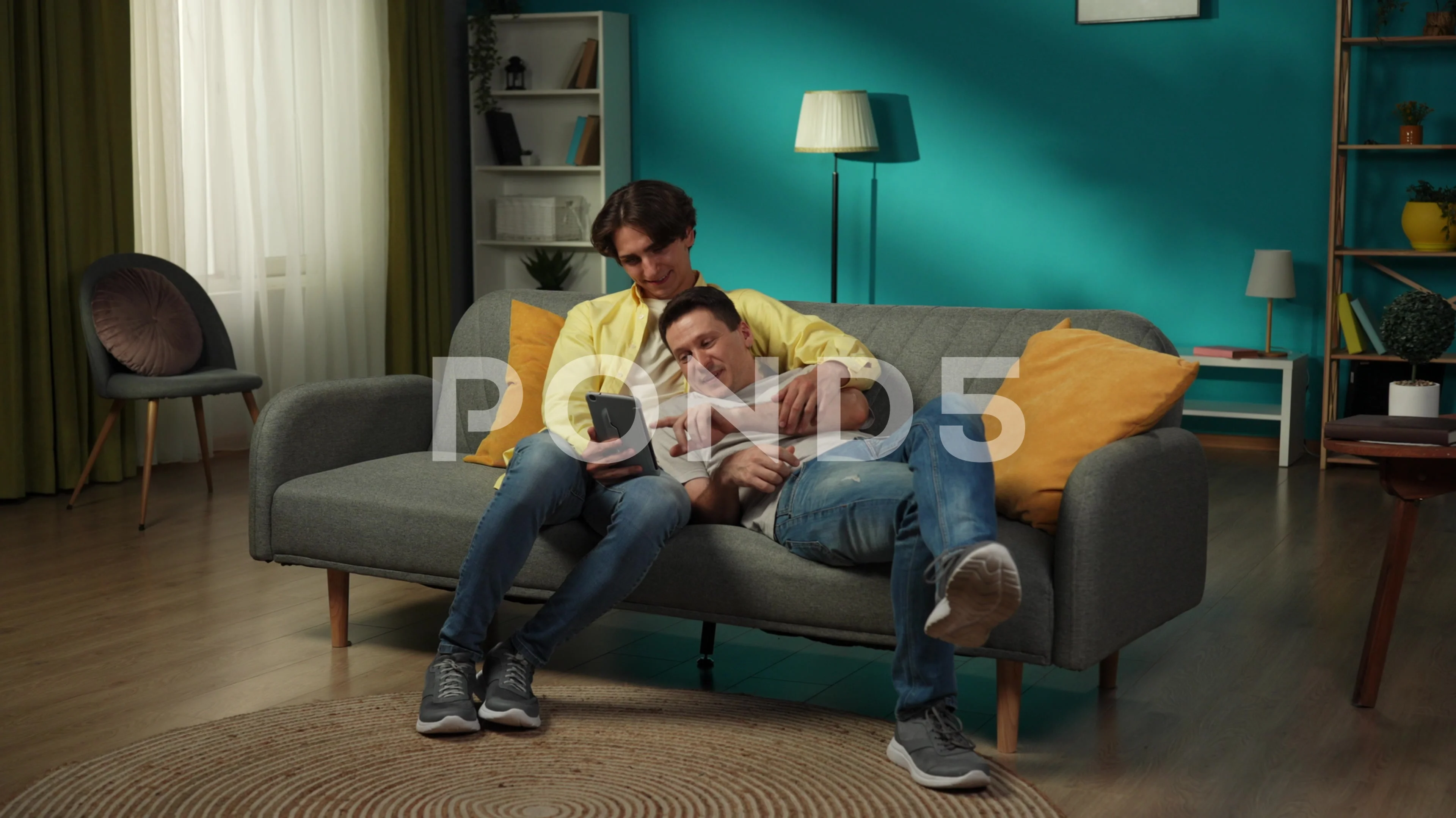 Full-size video of a homosexual couple at home. They are laying on the couch