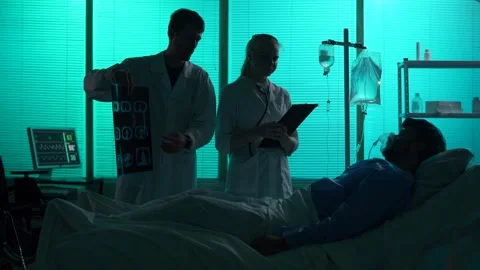 Full-sized silhouette video of two doctors standing next to a patient on a Stock Footage 251895731