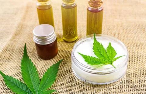 Full spectrum CBD and THC cannabis oils and cbd lotion on hemp cloth Stock Photos