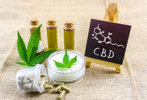 Full spectrum CBD and THC cannabis oils, pills and cbd lotion on hemp cloth w Stock Photos