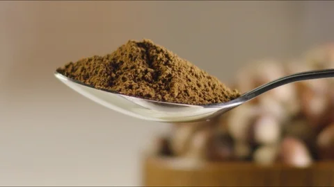 A full spoon of coffee. against the background of hazelnuts. slow Video stock 86571070