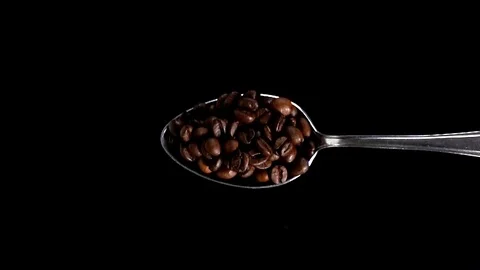 A Full Spoon Of Coffee falling down on black background closeup in super slow mo Video stock 121432919