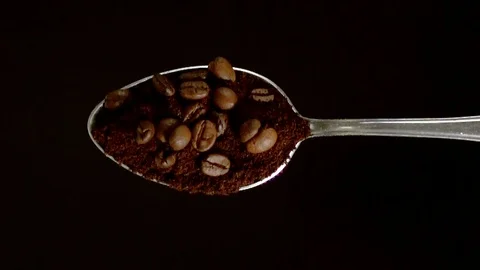 A Full Spoon Of Coffee falling down on black background closeup in super slow mo Stock Footage 121433103