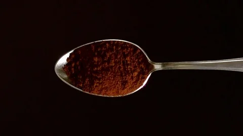 A Full Spoon Of Coffee falling down on black background closeup in super slow mo Stock Footage 121433527