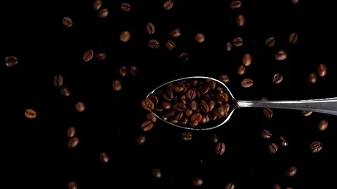 A Full Spoon Of coffee Flying up and Falling down on black background slow mo Stock Footage 121426976