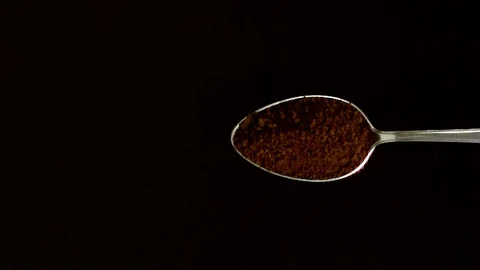 A Full Spoon Of coffee Flying up and Falling down on black background closeup in Stock Footage 121430381