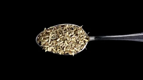 A Full Spoon Of exotic spice cumin falling seeds down on black background  動画素材 121430494