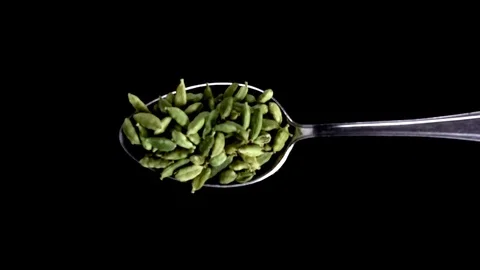 A Full Spoon Of exotic spice cumin seeds falling  down on black background close Stock Footage 121430558