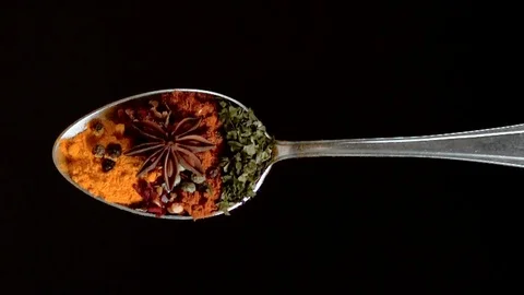A Full Spoon Of exotic spice falling down on black background closeup  super slo Stock Footage 121433473