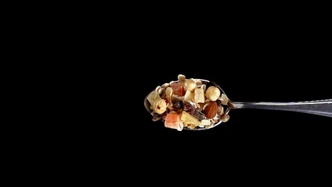 A Full Spoon Of fruit cereals Flying up and Falling down on black background clo Stock Footage 121426963