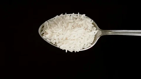 A Full Spoon Of rice falling down  on black background closeup in super slow mo Stock Footage 121433193