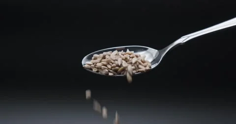 A full spoon of sunflower seeds falling in slow motion Stock Footage 148933507