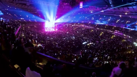A full stadium, thousands of audience members attend a concert performance Stock Footage 154987920