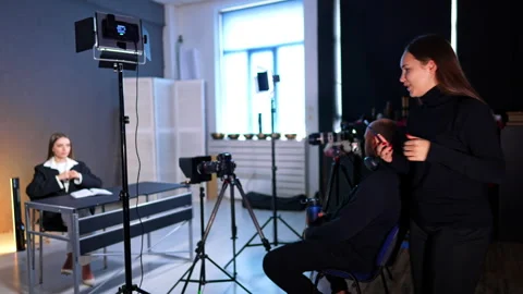 Full studio setup with host and crew during video production. Wide shot showing 動画素材 334812963