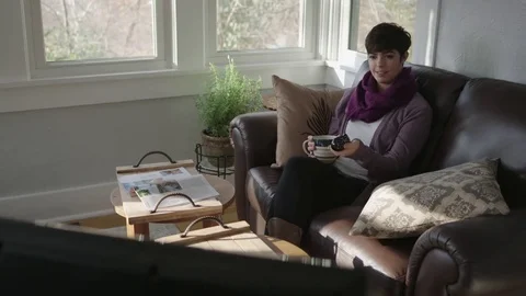 Full tracking shot of a lady in a sunroom relaxing watching TV Stock Footage 70809772