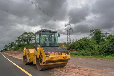 Full view of a road roller machine, leveling the ground with person to drive Stock Photos