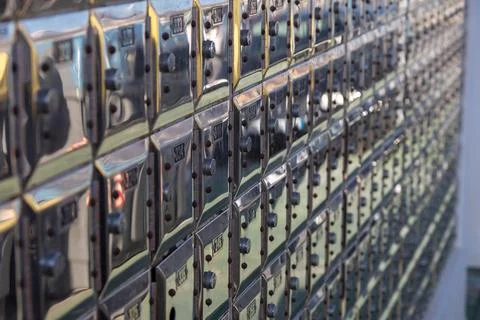 A full wall of gleaming, metallic post office boxes featuring individual lock Stock Photos