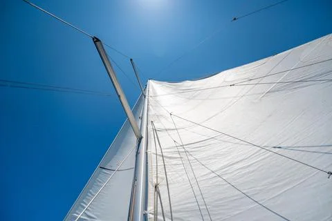 Full white sails blown by the wind against blue sky during sailing near Croatia Stock Photos
