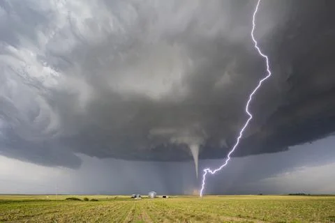 Fully Condensed Tornado with a lightning bolt from the clouds reaching the .. Stock Photos