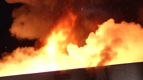 Fully engulfed building with large flames and orange smoke at night 스톡 동영상 160000179