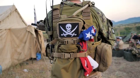 Fully equipped soldier. On the backpack is an image of a skull with two daggers 스톡 동영상 128824413