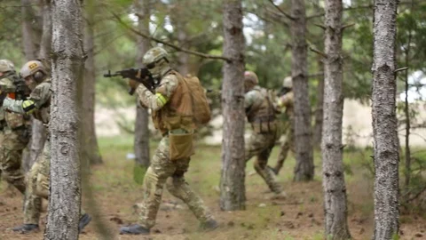Fully equipped soldiers moving through forest with rifle ready to shoot. Stock Footage 127648492