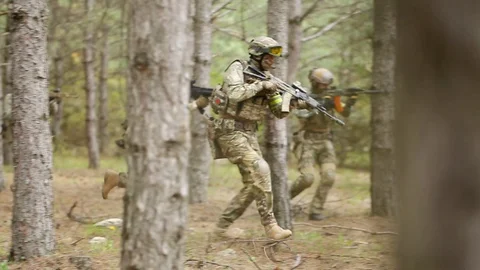 Fully equipped soldiers moving through forest with rifle ready to shoot. Stock Footage 127695468