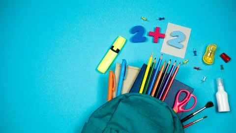 Fully filled school backpack on a bright background. Place for text on the left Stock Photos